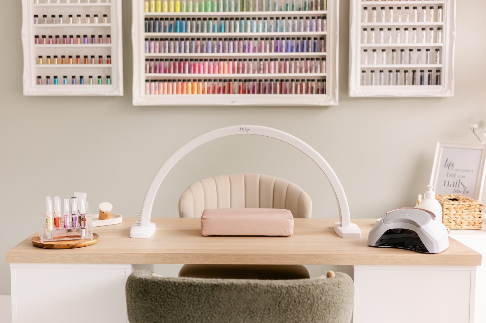 The nail station with its arch lamp and wall shelves of gel colours